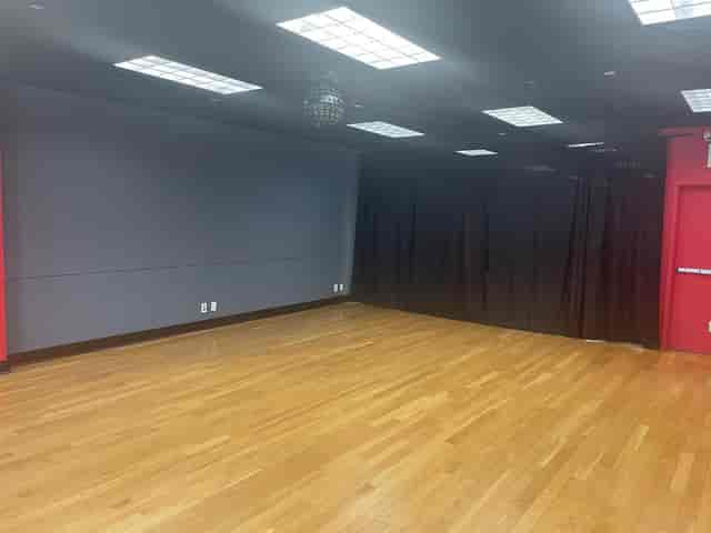 Versatile ballroom event space with polished wood floors, ideal for meetings and gatherings.