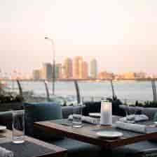 Stylish outdoor dining at Riverpark with waterfront view, ideal for upscale events.