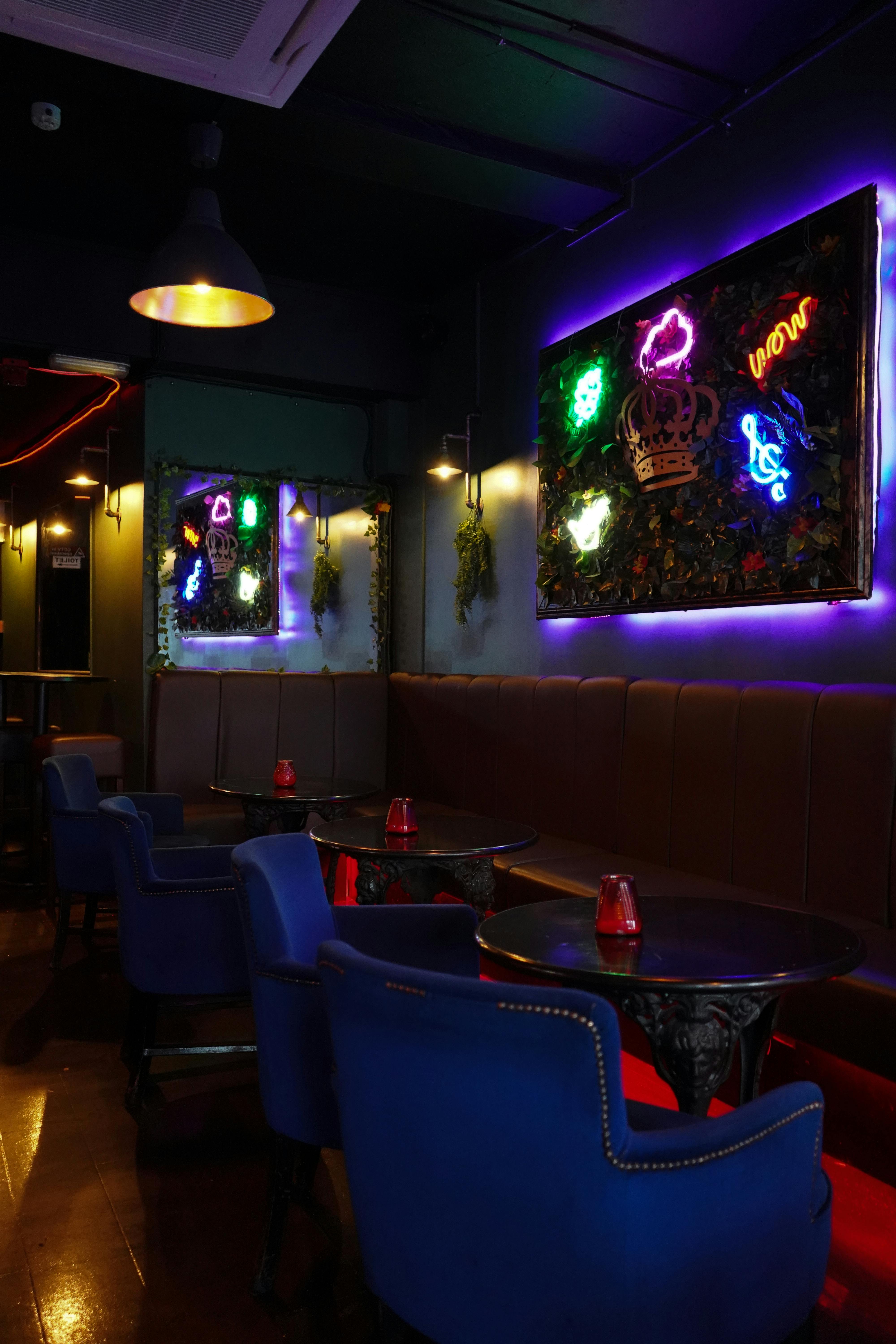 Stylish event space at TKL with plush seating and vibrant neon decor for gatherings.