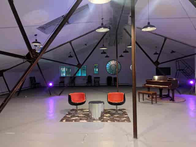 Versatile event space with unique design, stylish chairs, ideal for gatherings and networking.