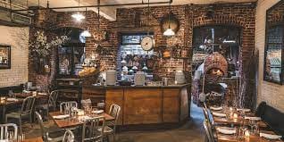 Rustic wine bar with exposed brick, ideal for intimate gatherings and casual meetings.