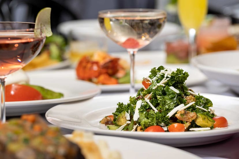 Elegant dining table with gourmet dishes and vibrant salad at Arte Cafe for upscale events.