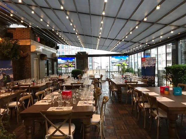 Open-air terrace event space with elegant tables, ideal for corporate gatherings and dinners.