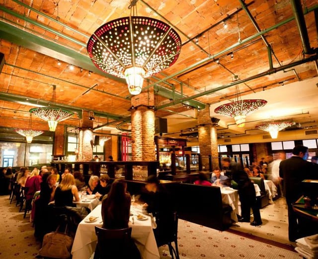 Main Dining Room at Tribeca Grill, vibrant venue for events with warm lighting.