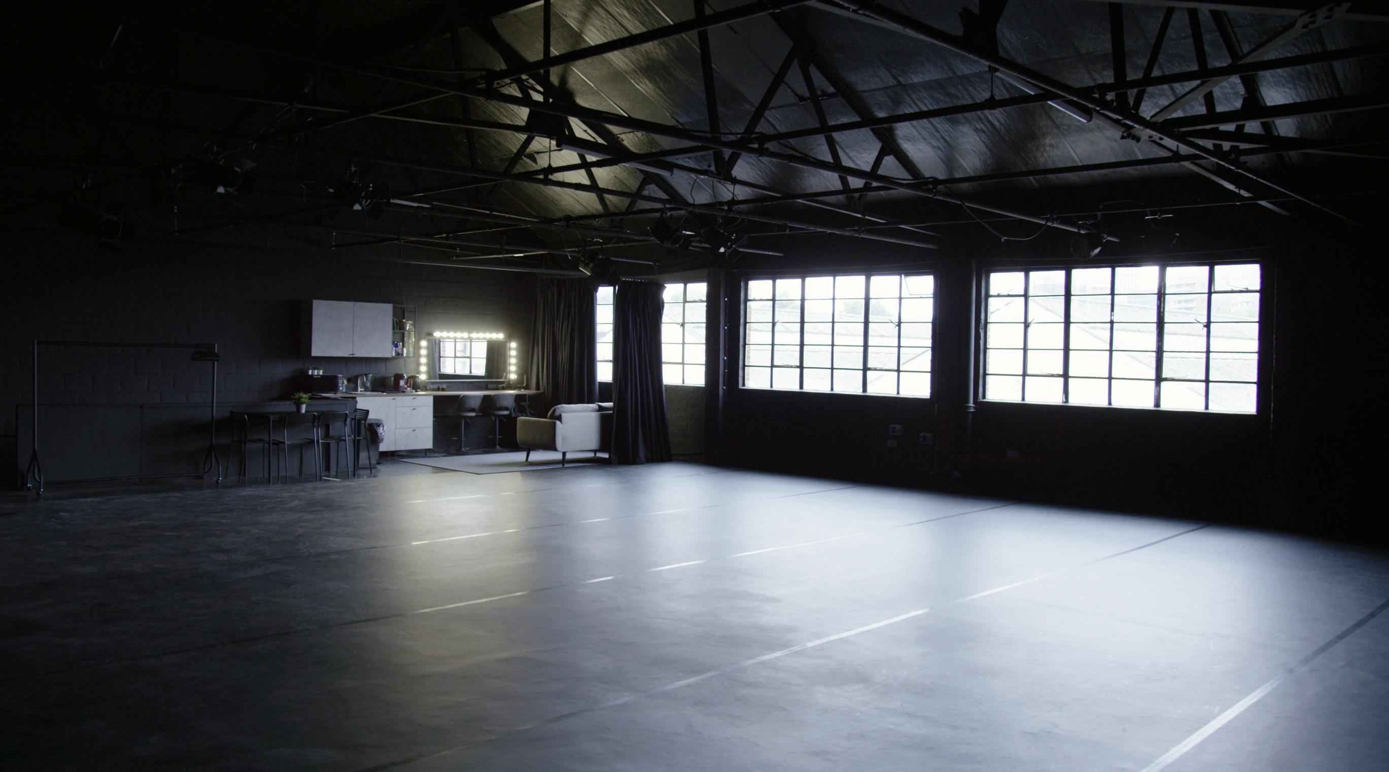 Versatile industrial event space with large windows for meetings and workshops.