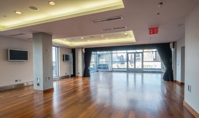 Versatile penthouse event space with large windows, ideal for corporate meetings and gatherings.