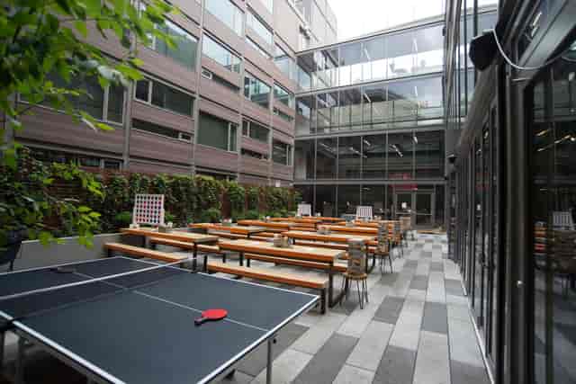 Outdoor event space at Clinton Hall, featuring communal tables and ping pong for networking.