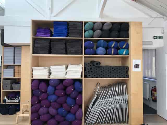 Organized storage with yoga mats and bolsters in a wellness studio for yoga retreat breakout rooms.