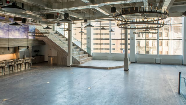 Versatile Lower Mezzanine event space with natural light, ideal for meetings and gatherings.