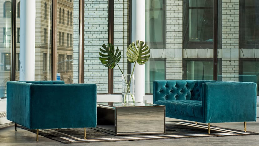 Stylish lounge with teal sofas and natural light, ideal for events and networking.