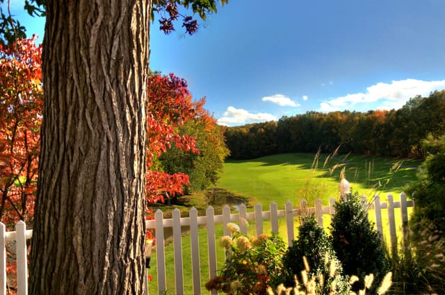 Private events at Grand Oaks Country Club with autumn foliage and charming white fence.