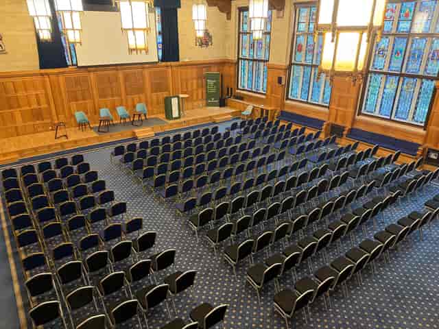 The Great Hall wood-paneled lecture venue set up for a keynote presentation or academic symposium.