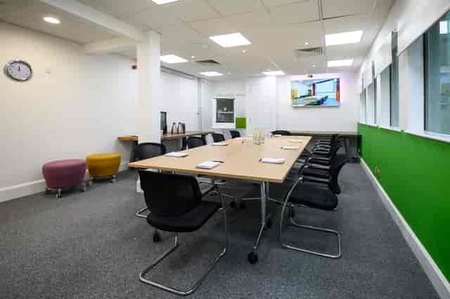 Modern meeting room with spacious table, ergonomic chairs, ideal for workshops and presentations.