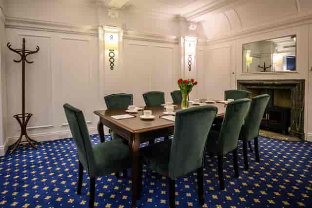 Elegant President Suite meeting room with plush green chairs, perfect for small gatherings.