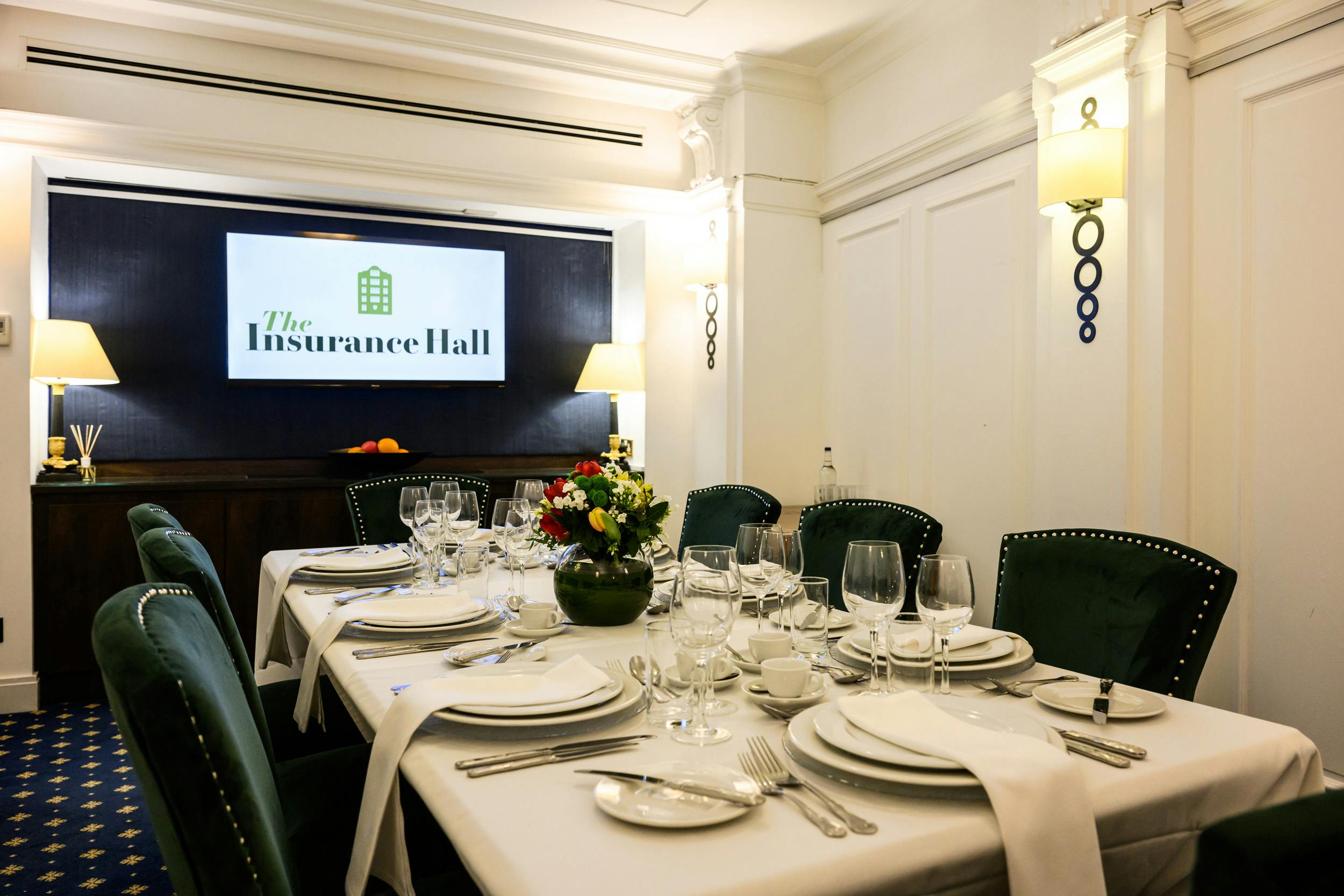 Elegant President Suite meeting space for corporate events with fine china and floral decor.