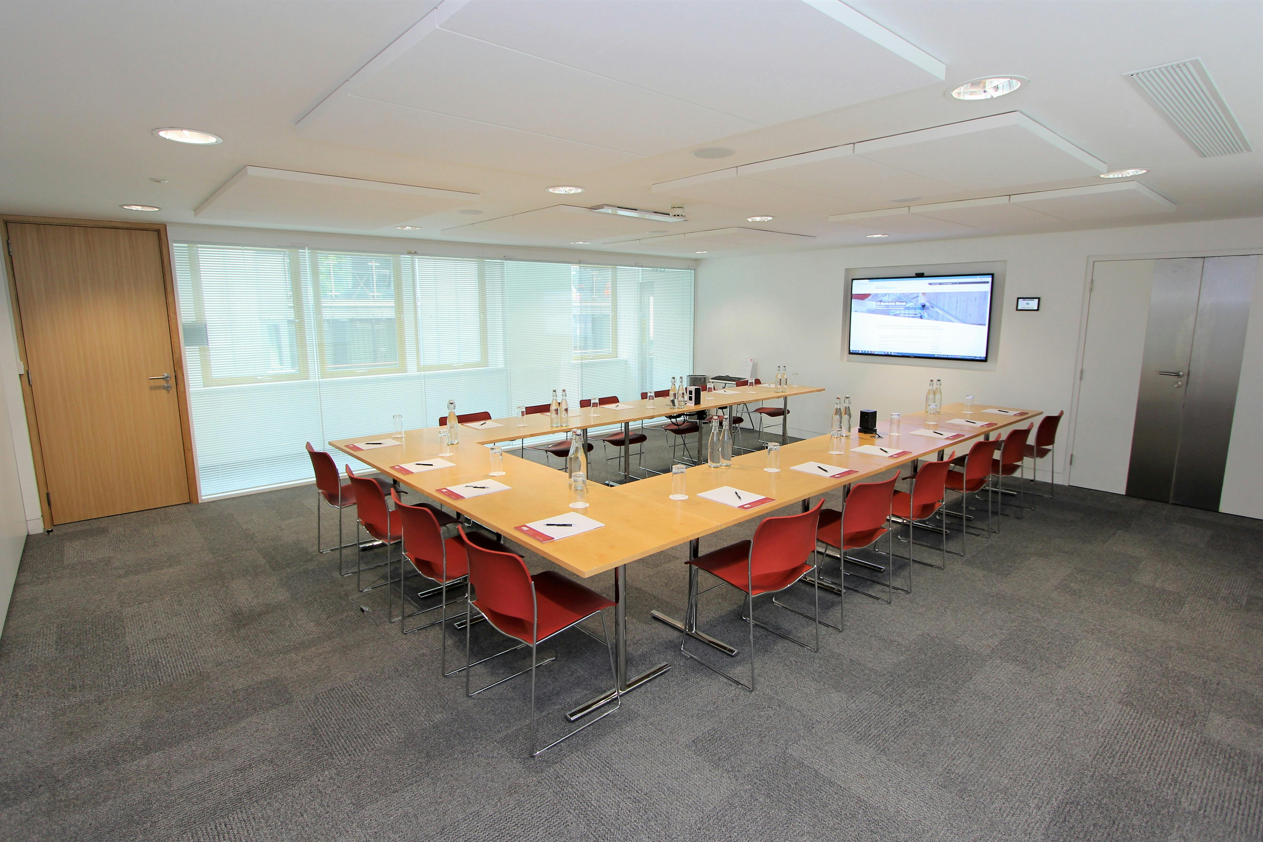 Modern meeting room with long table, ideal for presentations and collaboration.