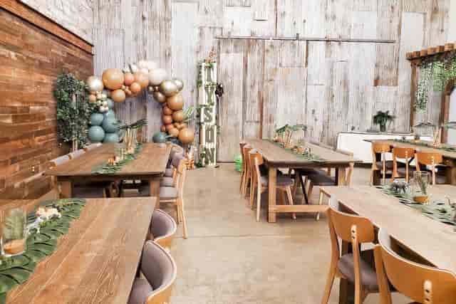 Elegant event space at The Garden Alexandria with rustic tables and a balloon arch.