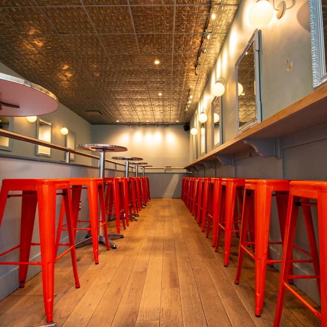 Enhanced cocktail experience at Morris American Bar with vibrant orange stools.