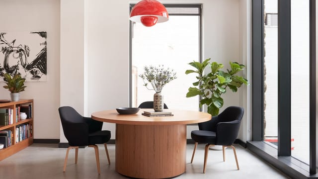 Modern meeting space with round table and black chairs at WeWork 1701, D.C.