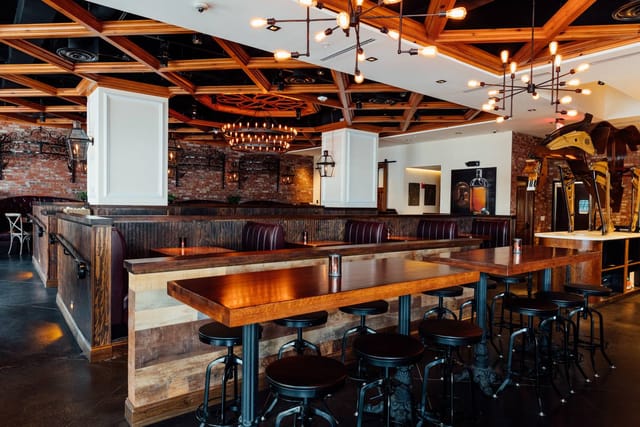 Full Mezzanine at Succotash DC, stylish venue for events with wooden tables and warm lighting.