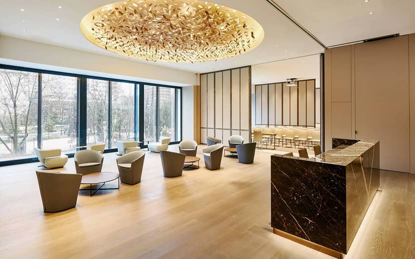 Modern meeting space in VP Plaza España, Madrid with stylish seating and chandelier.