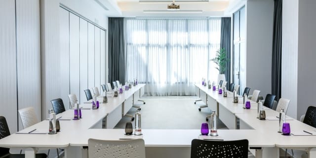 Modern meeting room with U-shaped table, ideal for workshops in Barcelo Imagine Hotel, Madrid.