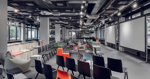 Versatile event space with colorful chairs for dynamic meetings in Frankfurt.