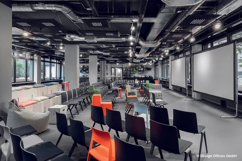 Versatile event space with colorful seating in Design Offices Frankfurt for meetings and workshops.
