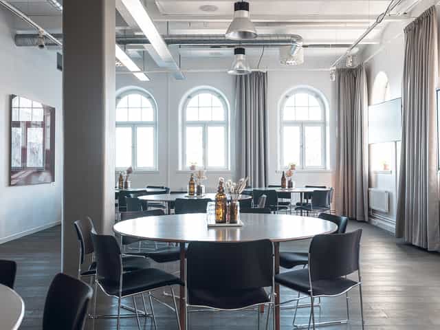 Modern event space in Fotografiska, Stockholm with round tables for workshops and networking.