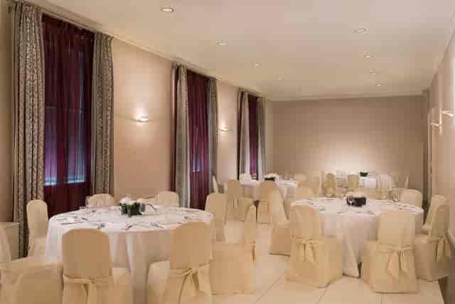 Elegant event space at Sheraton Diana Majestic, Milan with round tables and soft lighting.