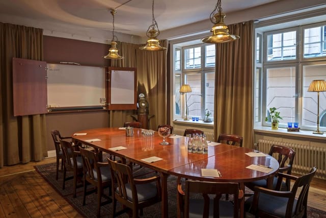 Elegant meeting room with wooden table, ideal for workshops in Sjöfartshuset, Stockholm.