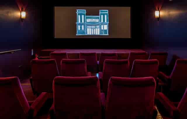 Cozy screening room with plush red seating for private film events and gatherings.