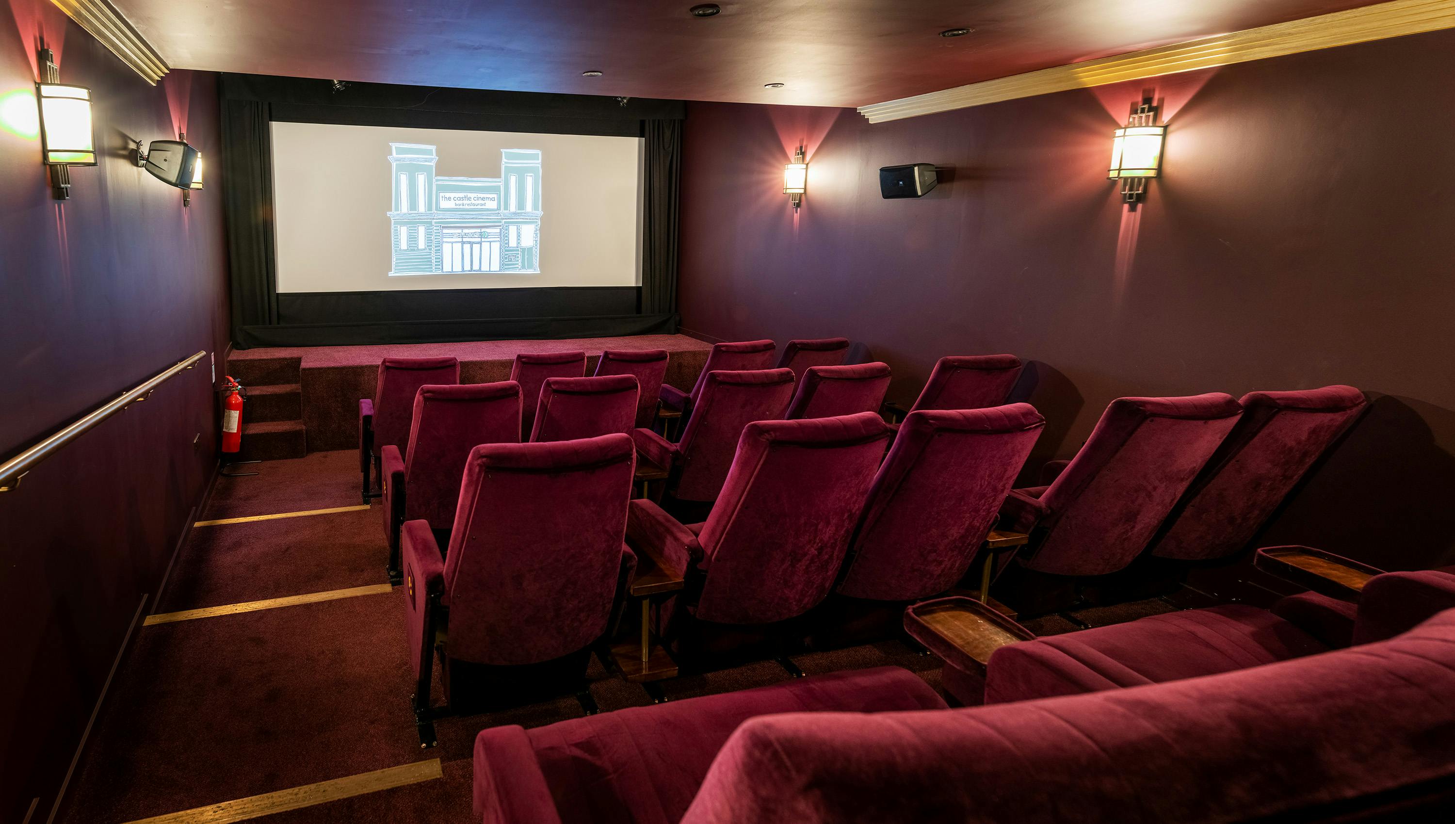 Cozy screening room with burgundy seating for private film events and presentations.