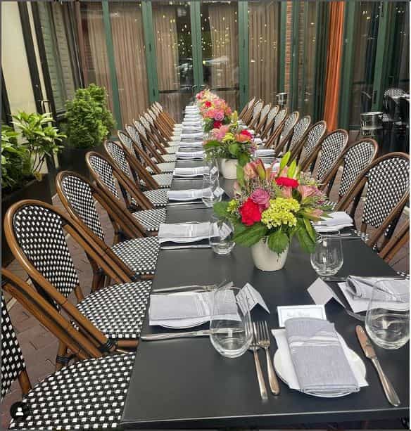 Elegant outdoor dining setup with floral centerpieces for corporate events.