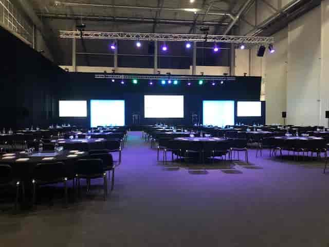 Conservation Hall at IWM Duxford, set for a conference with round tables and stage.