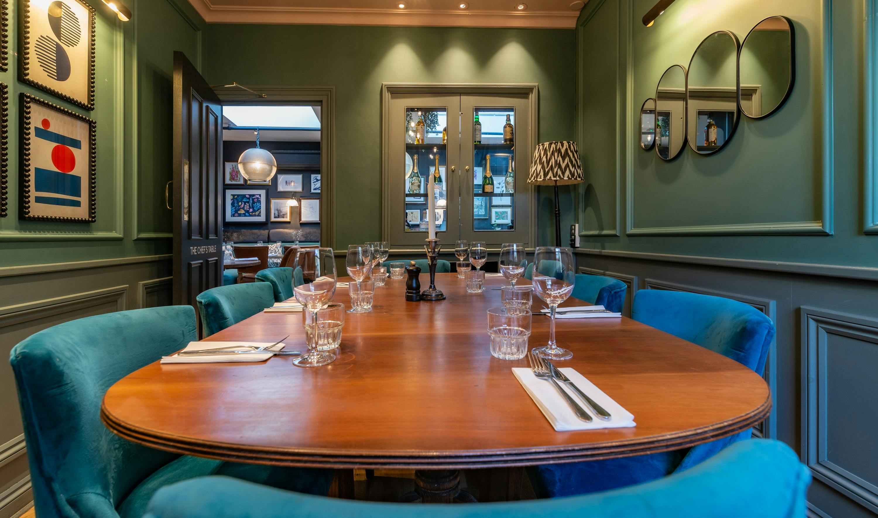 Elegant Chef's Table meeting room with blue chairs for intimate gatherings and strategy sessions.