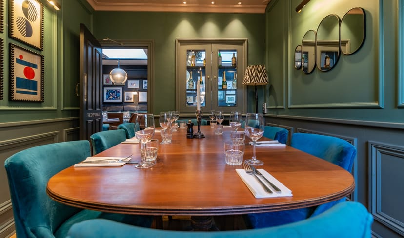 Elegant Chef's Table meeting room with blue chairs for intimate gatherings and strategy sessions.