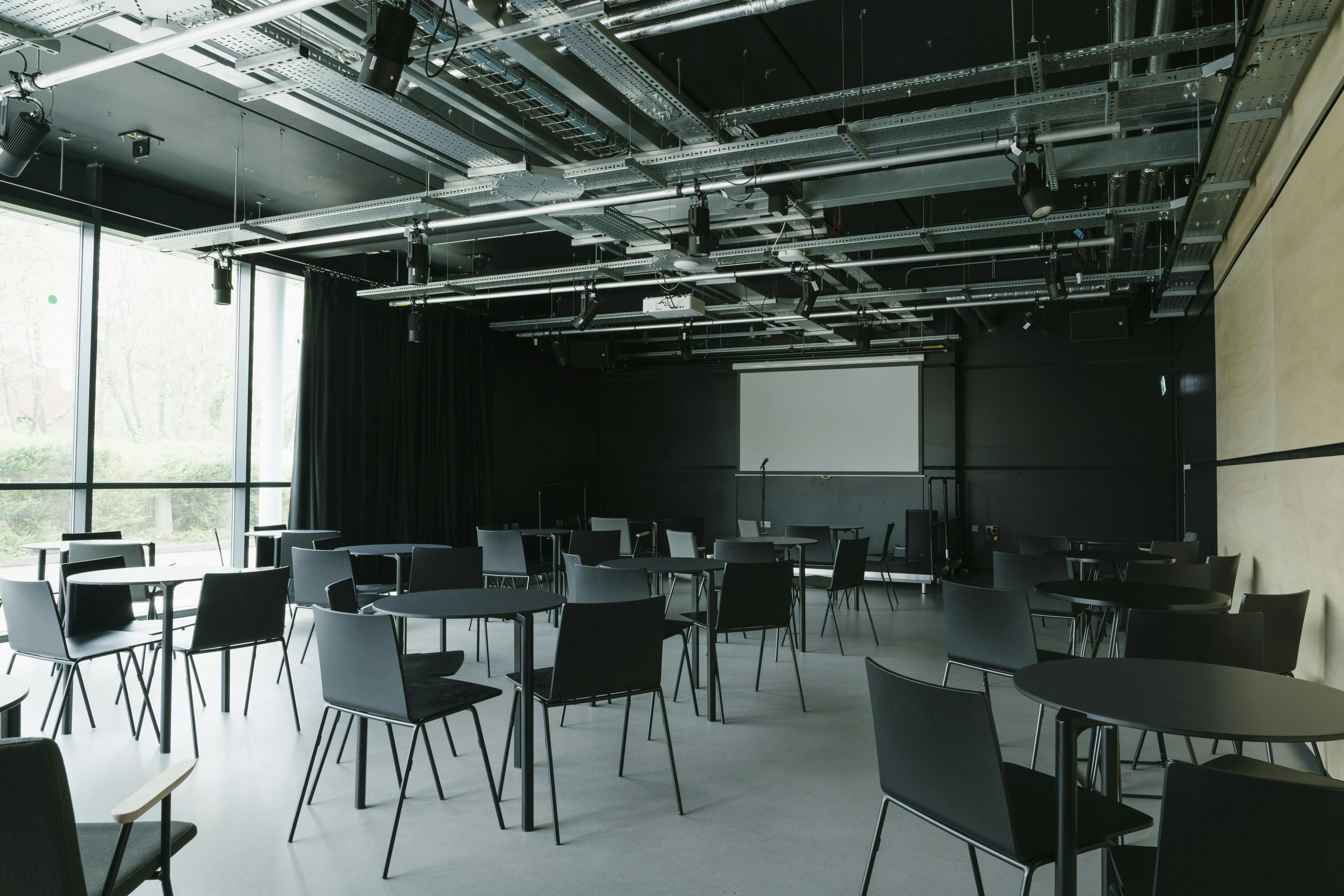 Versatile event space with modular seating, ideal for corporate meetings and social gatherings.