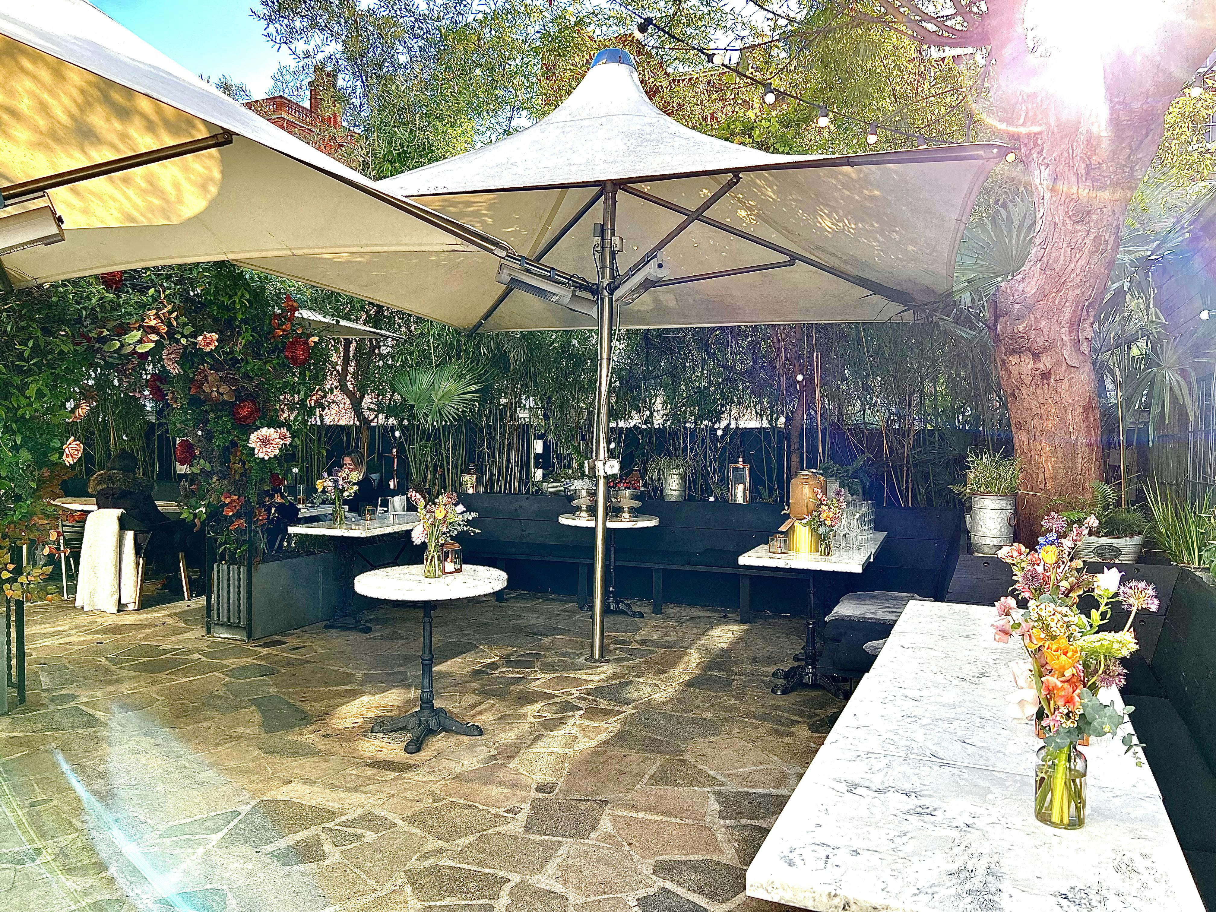 Elegant outdoor event space with floral centerpieces at The Phene garden.