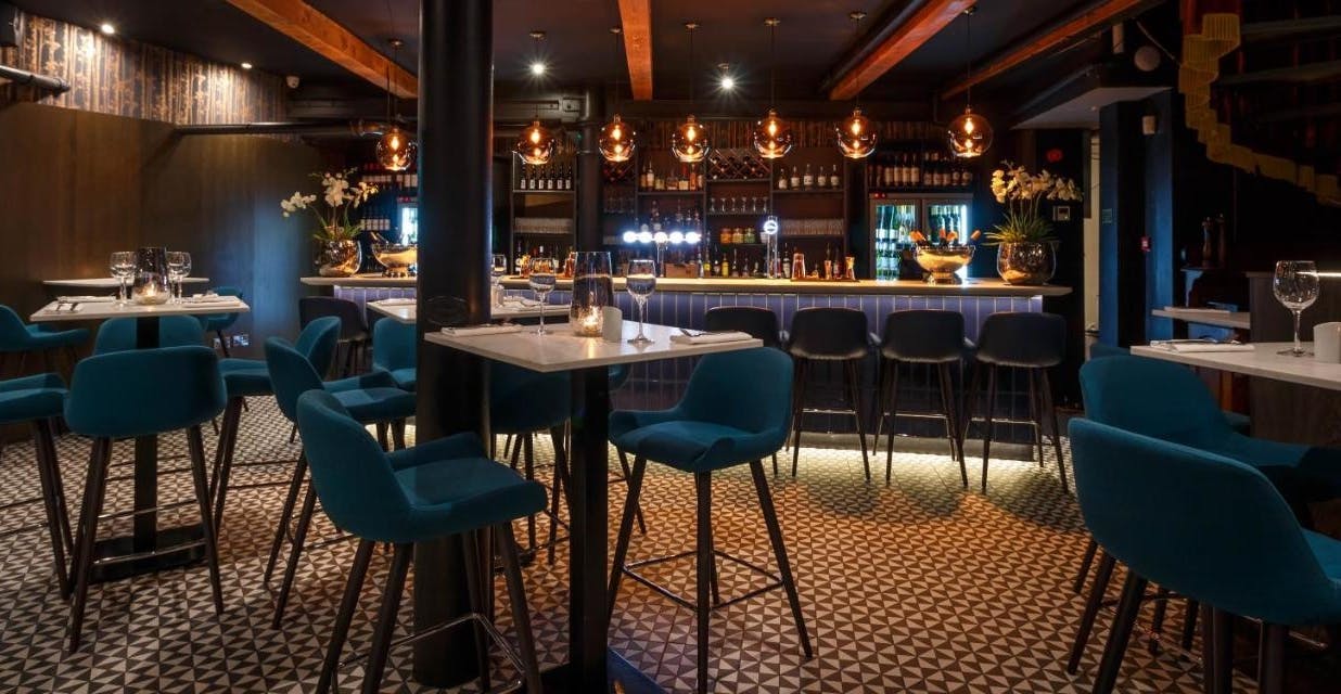 Stylish bar at Velvet Brasserie with blue seating, perfect for events and gatherings.