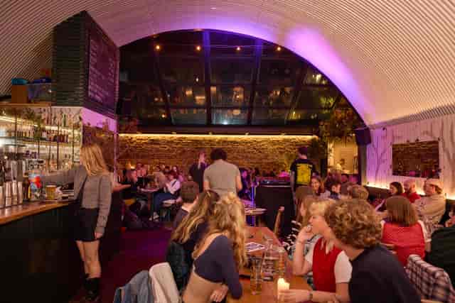 Vibrant bar area with glass ceiling, perfect for networking events and social gatherings.
