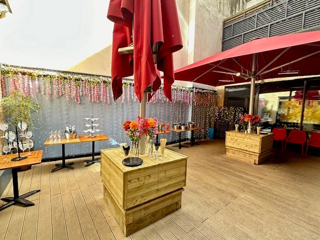 Stylish outdoor event space with red umbrellas, ideal for cocktail receptions and gatherings.