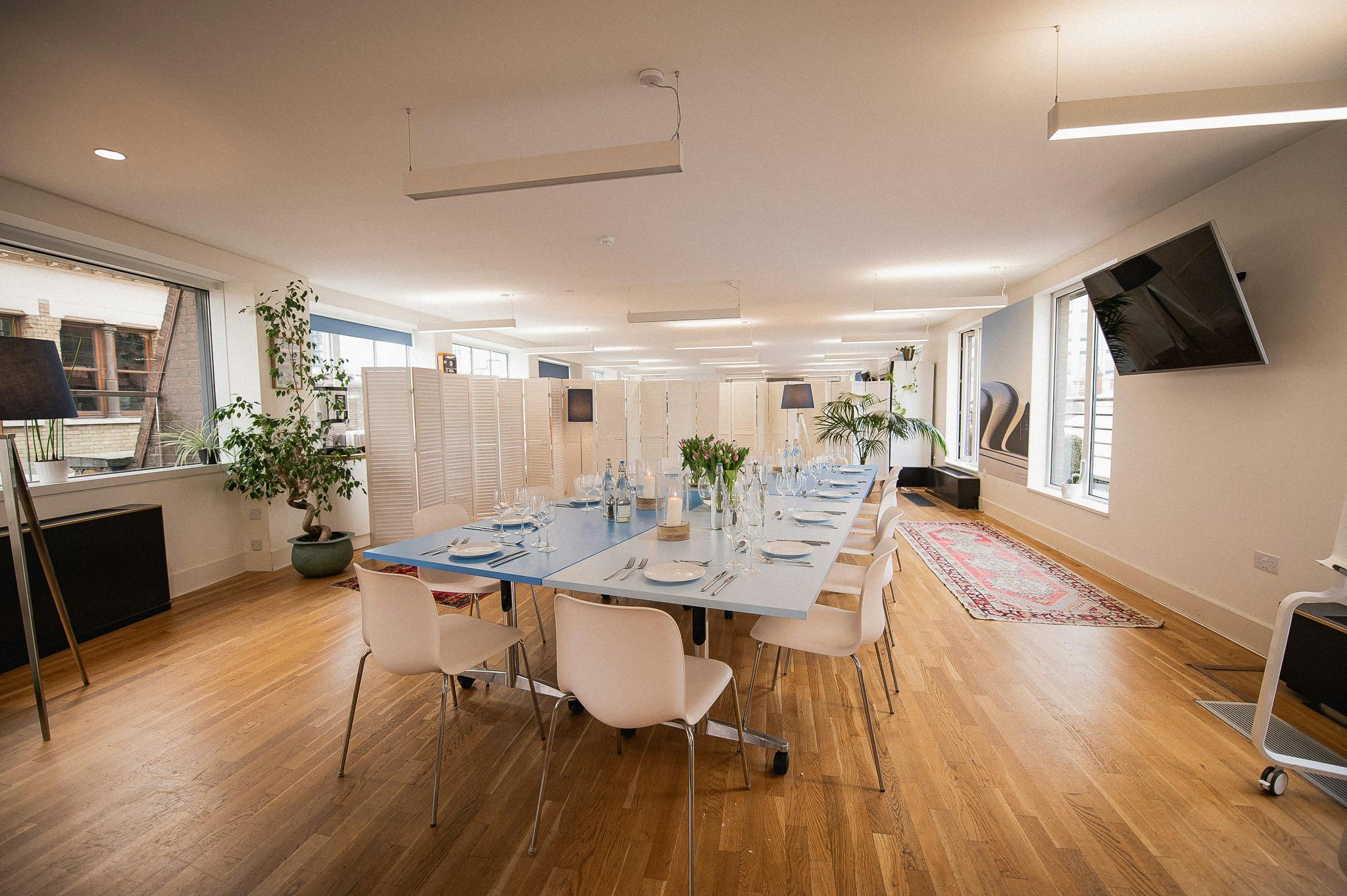 Rooftop Kitchen meeting space with elegant table settings for corporate events.