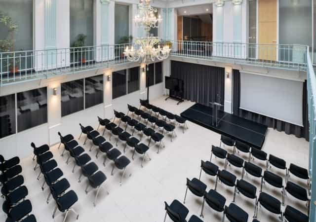 La Verriere Clery event space with sleek chairs and elegant chandelier for corporate gatherings.