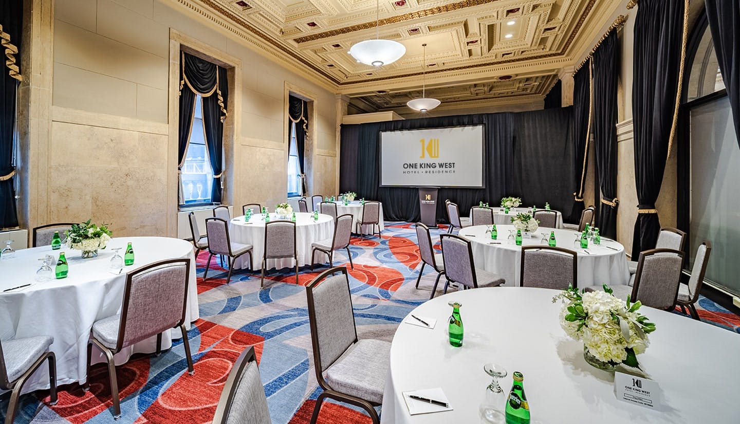 The King Gallery at One King West, featuring elegant round tables for corporate events.