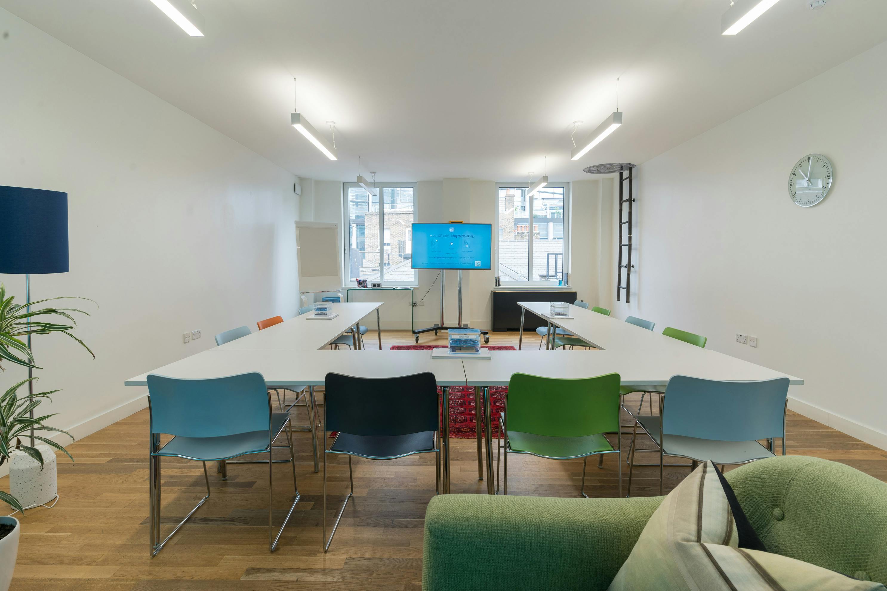 Modern meeting room with colorful chairs, ideal for workshops and brainstorming sessions.