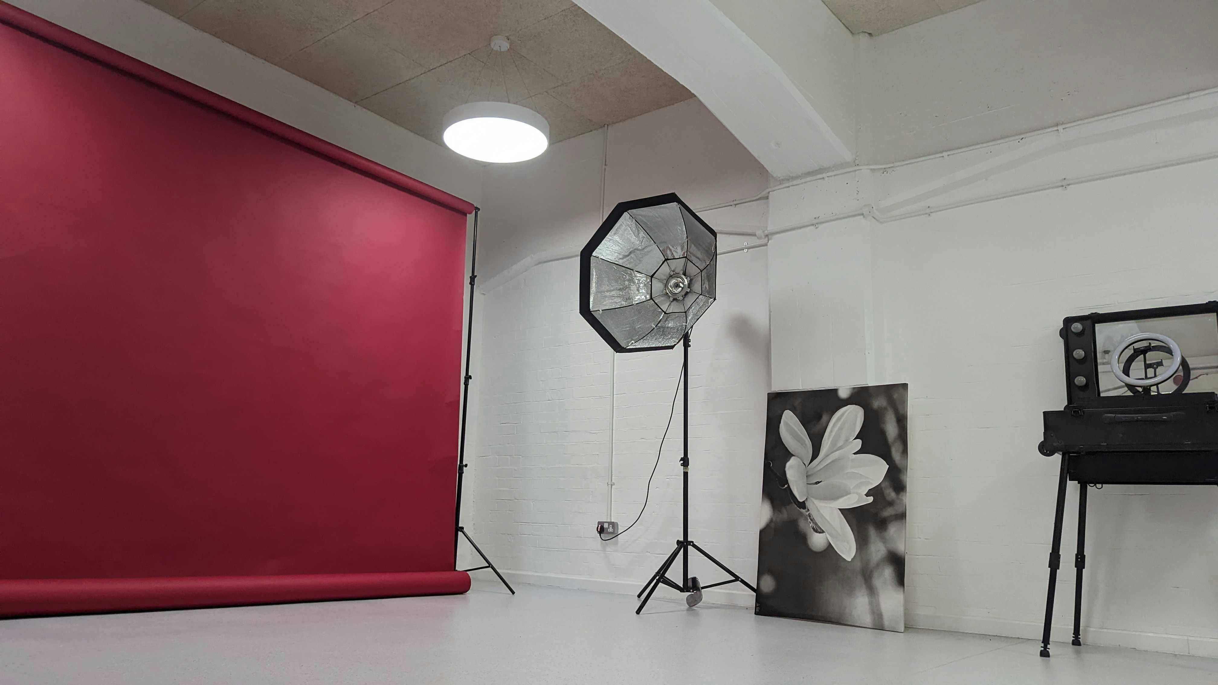 Vision Wharf Studios event space with red backdrop, ideal for workshops and gatherings.