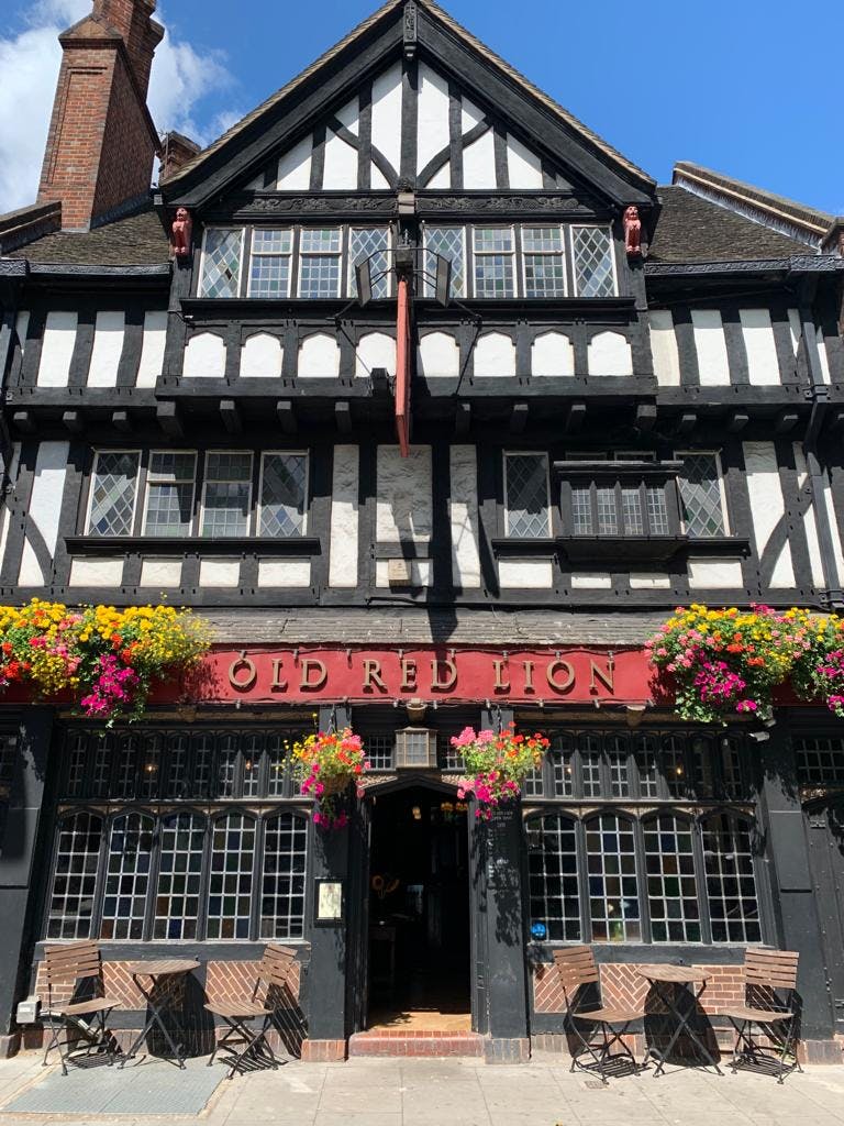 Red Room at The Old Red Lion: charming venue with vibrant flowers for intimate events.