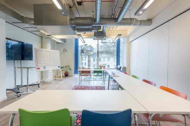 Modern meeting room at Wallacespace with colorful chairs, ideal for presentations and brainstorming.