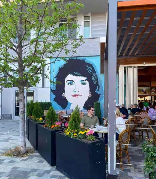 Outdoor dining at Jackie-American Bistro with vibrant mural, perfect for events and gatherings.